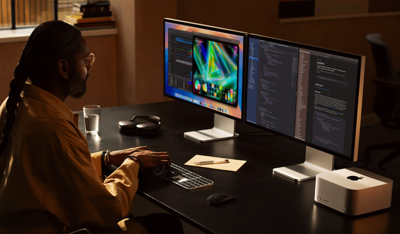 一位專業人士在已連接兩部 Studio Display 的 Mac Studio 上工作
