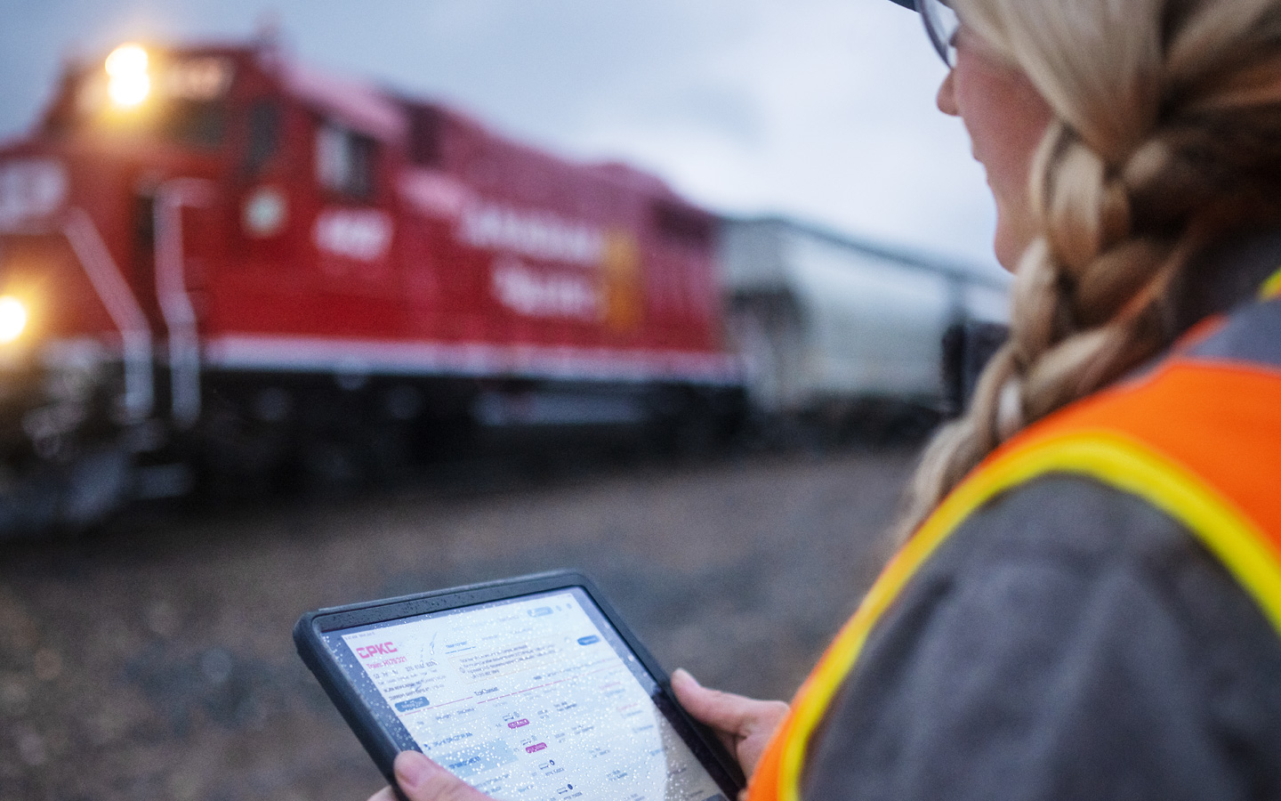 Uma funcionária da ferrovia analisa os horários dos trens no iPad no pátio ferroviário