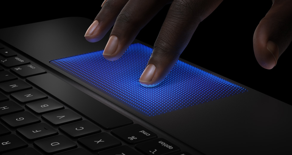 Animation einer Hand mit Fingern, die über dem Magic Keyboard Trackpad schweben, Zeigefinger mit blauem Schatten zeigt die Tipp Aktion, um das haptische Feedback zu demonstrieren
